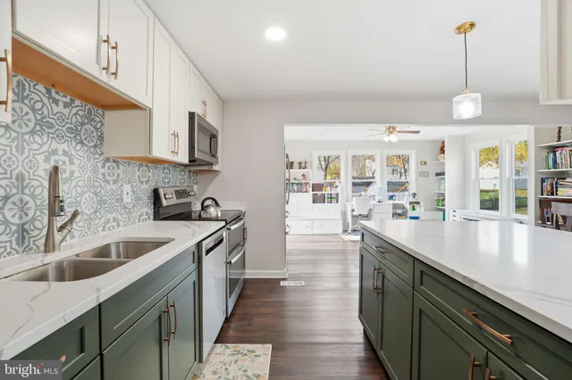 a kitchen with stainless steel appliances granite countertop a sink a stove and a wooden floors