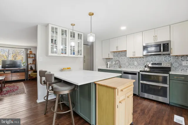 a open kitchen with stainless steel appliances kitchen island a table chairs in it and a window