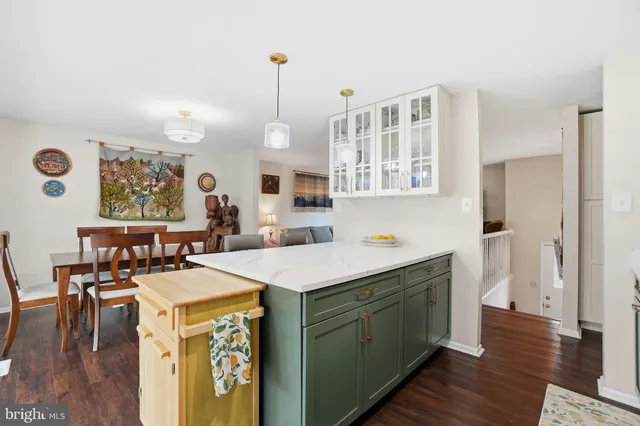 a view of a kitchen counter space with wooden floor and windows