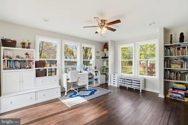a living room with furniture hard wood floor and a book shelf