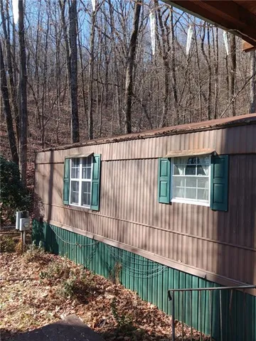 a view of a house with a small yard and wooden fence