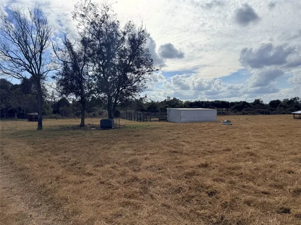 a view of a field with trees in the background