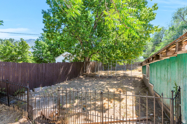 44 North 300 West Springville, UT 84663 - Photo 19 of 24 Fenced backyard with mature trees, a privacy fence, and mountain scenery in the distance