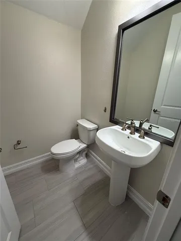 a bathroom with a sink a toilet and mirror
