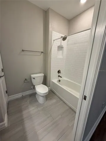 a white toilet sitting next to a bathroom sink and tub