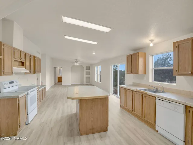 a large kitchen with stainless steel appliances lots of counter space and wooden floor