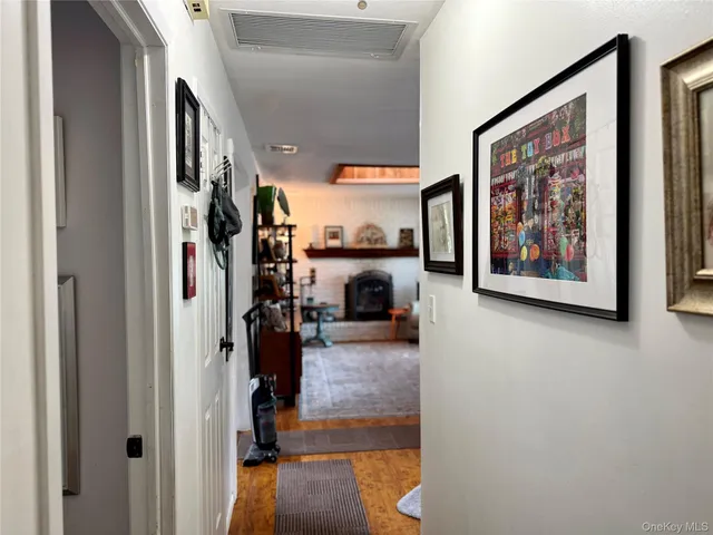 a view of a hallway with wooden floor and furniture