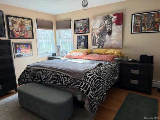 a bedroom with a bed and painting on the wall