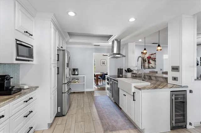 a large kitchen with stainless steel appliances lots of counter space and wooden floor
