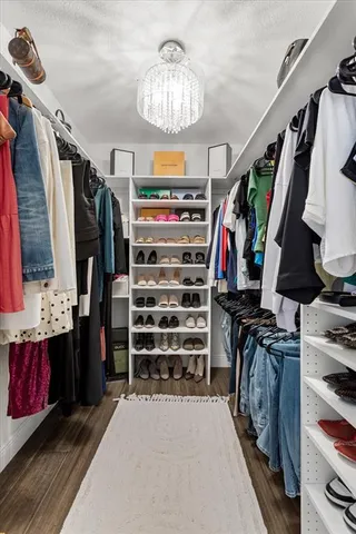 a view of walk in closet with clothes and shoes