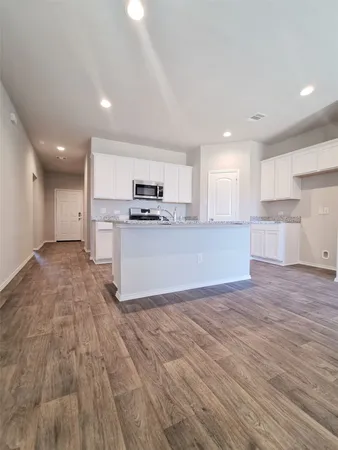 a large kitchen with stainless steel appliances a large counter top a sink and a stove