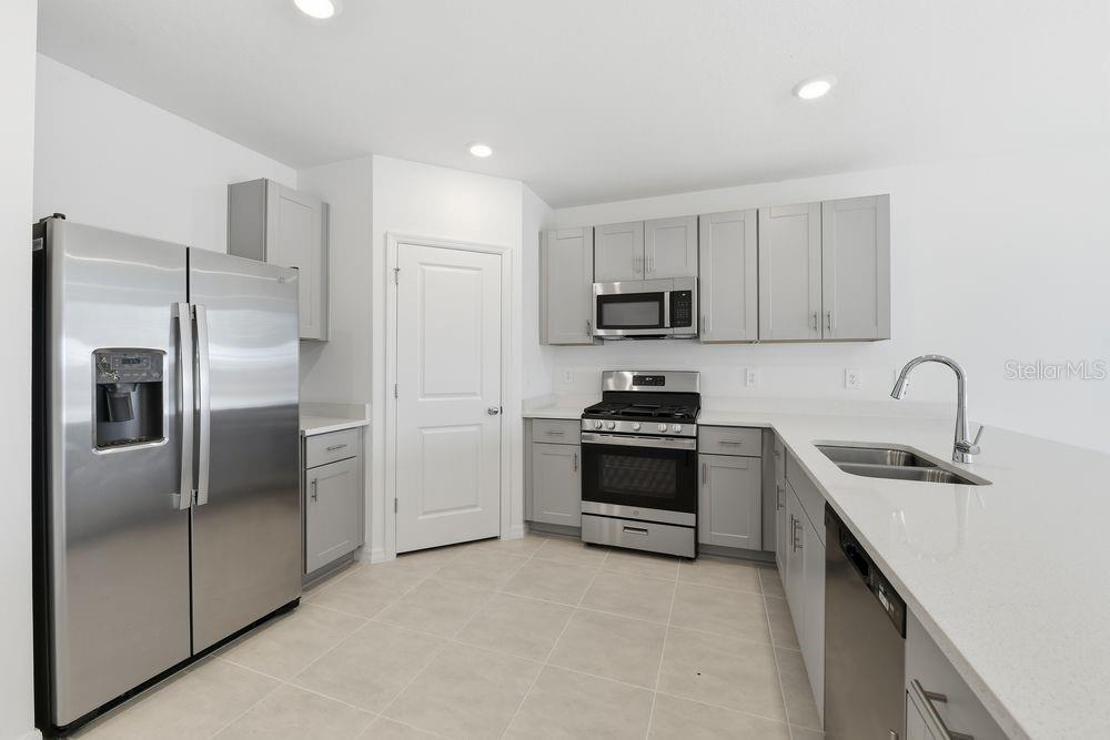 13231 Commons Avenue Parrish, FL 34219 - Photo 2 of 40 a kitchen with stainless steel appliances a refrigerator sink and white cabinets