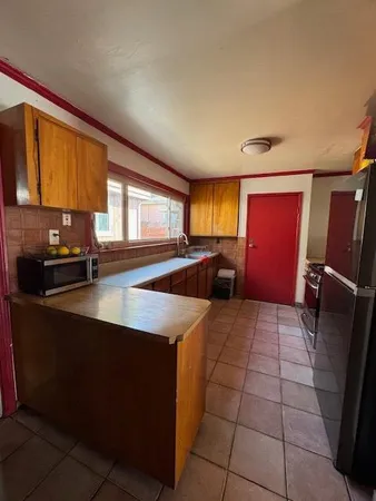 a kitchen with stainless steel appliances a sink a stove cabinets and a counter top space