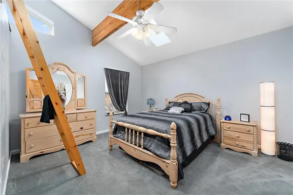 a spacious bedroom with a bed and a chandelier