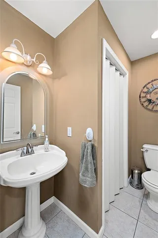 a bathroom with a sink a toilet and a mirror
