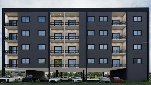 an aerial view of a city with lots of residential buildings ocean and mountain view in back