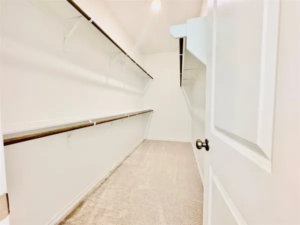a view of a kitchen with white cabinets and entryway