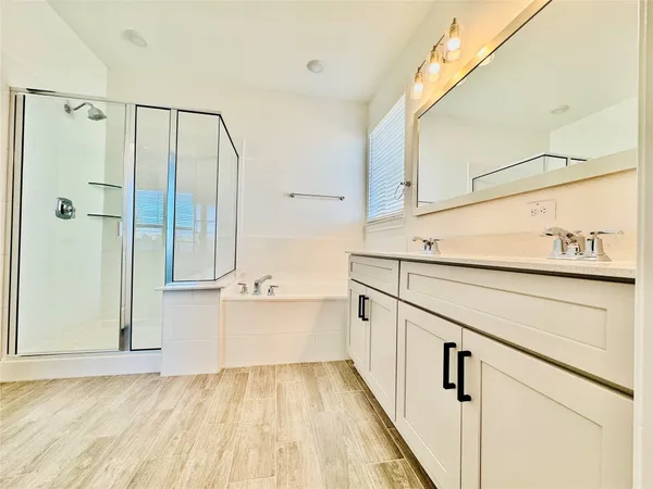 a view of a kitchen with white cabinets and wooden floor
