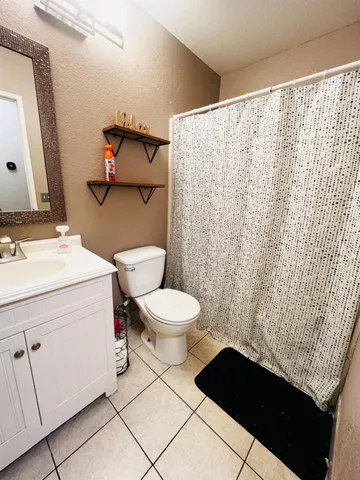 a bathroom with a toilet and a shower curtain