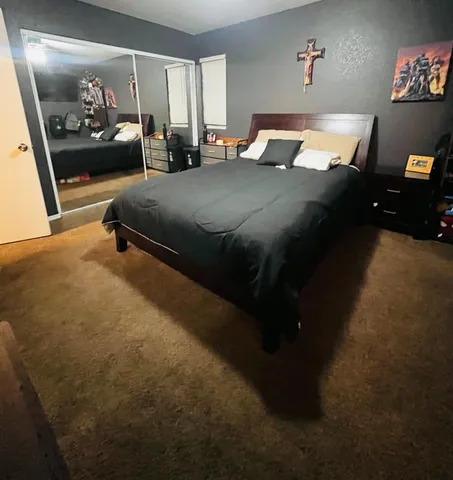 a bed sitting in a bedroom next to a lamp