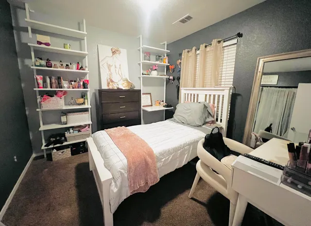 a bedroom with a bed and a book shelf