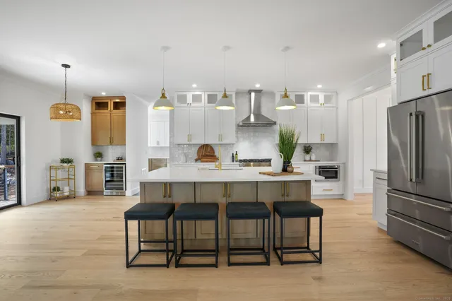a large kitchen with kitchen island a large counter space and stainless steel appliances