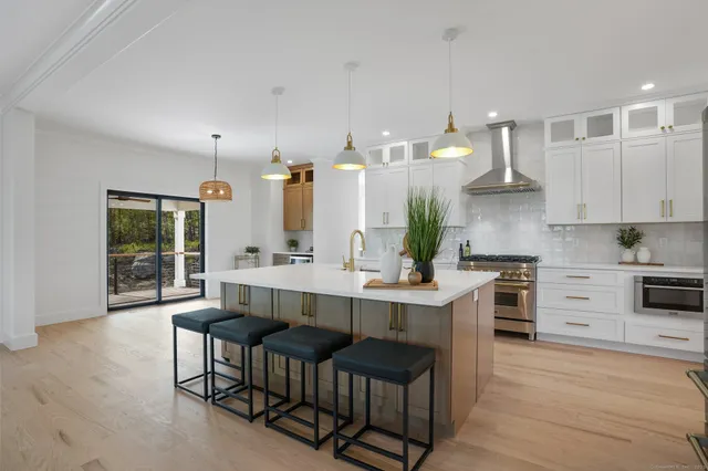 a view of an empty room with a kitchen and a window