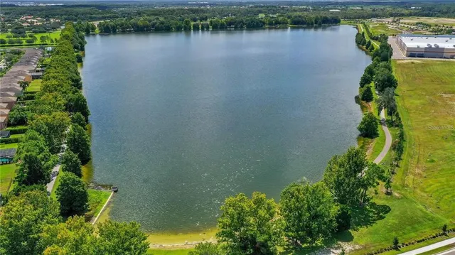 an aerial view of a residential houses with outdoor space and lake view
