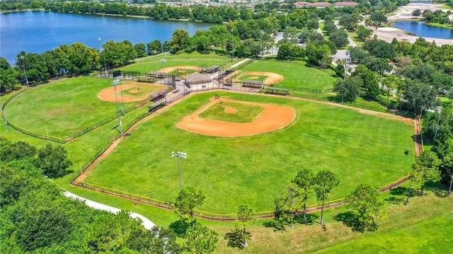 an aerial view of a residential houses with outdoor space and lake view