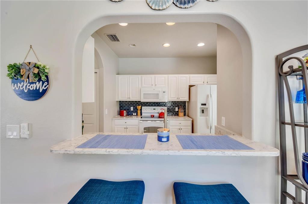 280 Cape Harbour Loop, Unit 101 Bradenton, FL 34212 - Photo 6 of 35 a kitchen with stainless steel appliances a white table chairs and a refrigerator