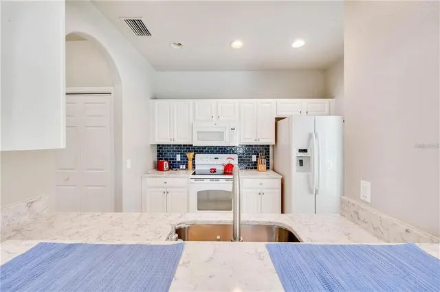 a kitchen with stainless steel appliances a refrigerator and wooden floor
