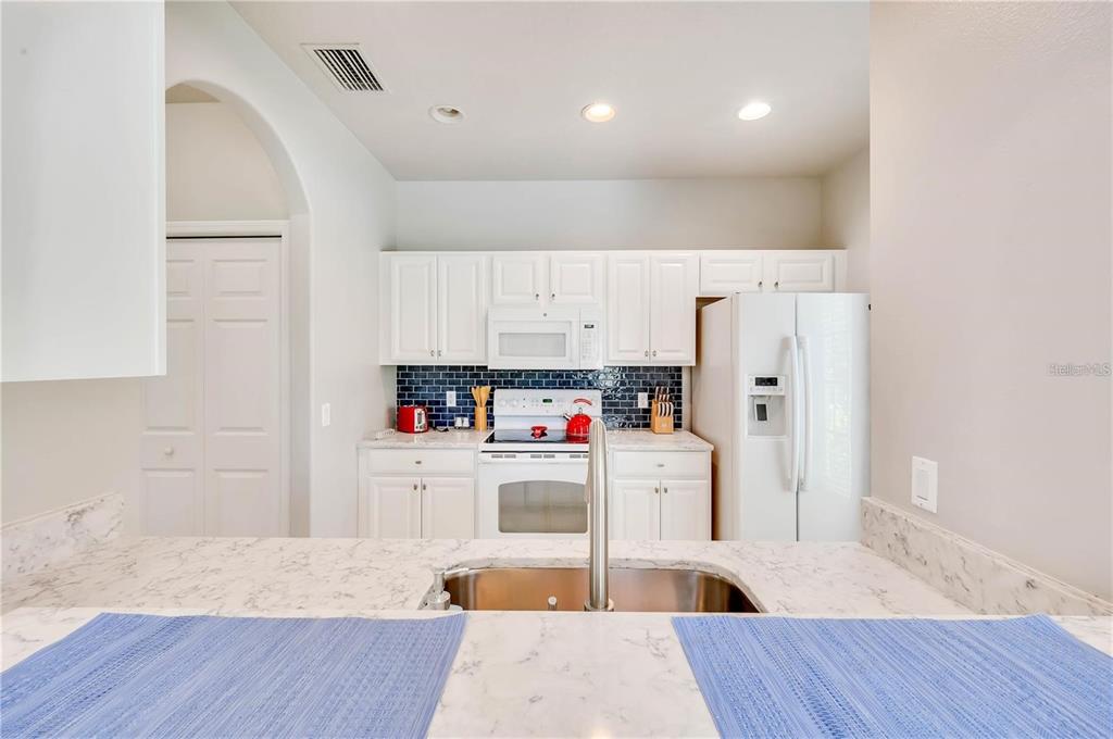 280 Cape Harbour Loop, Unit 101 Bradenton, FL 34212 - Photo 7 of 35 a kitchen with stainless steel appliances a refrigerator and wooden floor