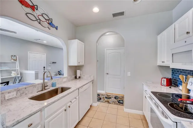 a kitchen with granite countertop a sink stainless steel appliances and cabinets