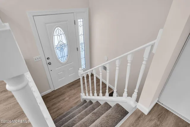 a view of a hallway with wooden floor and staircase