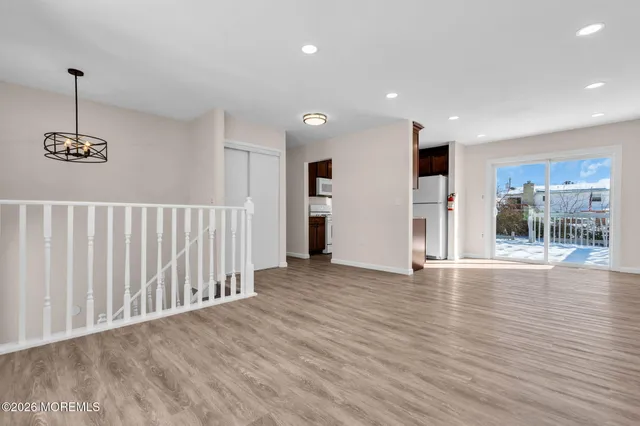 a view of a room with wooden floor and windows