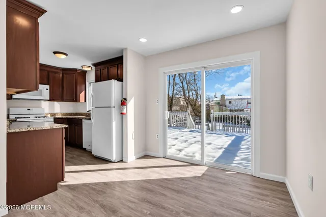 a view of a kitchen with wooden floor and electronic appliances