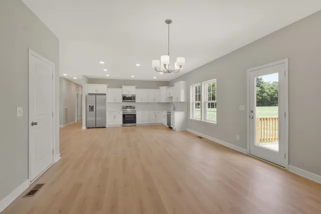 a view of empty room with a kitchen and windows