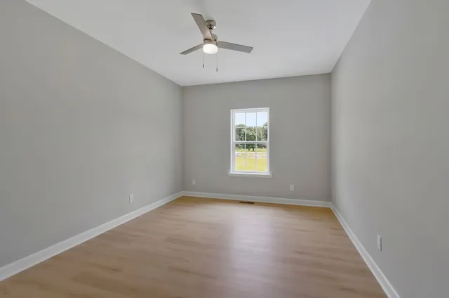 an empty room with a window and a fan