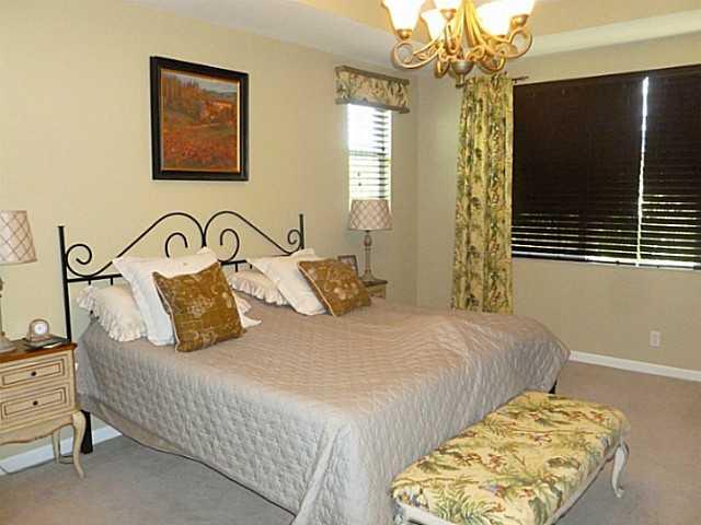 150 Southwest Walking Path Stuart, FL 34997 - Photo 15 of 25 a bedroom with a bed and a chandelier