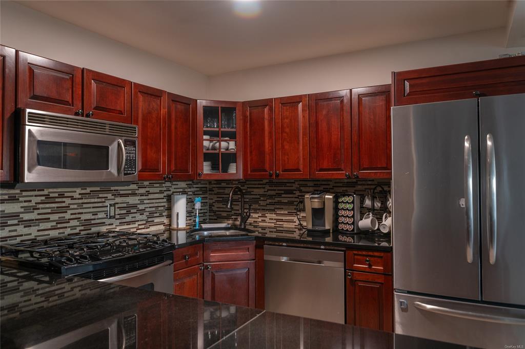 374 Hill Road Jeffersonville, NY 12748 - Photo 10 of 36 Kitchen with backsplash, dark stone countertops, sink, and stainless steel appliances