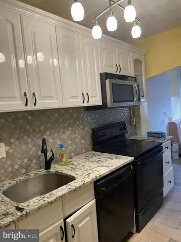 a kitchen with stainless steel appliances granite countertop a sink a stove and a microwave