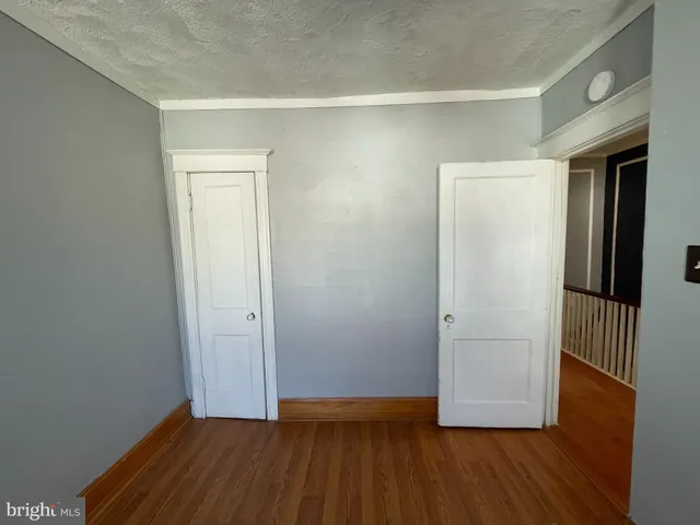 an empty room with wooden floor and closet