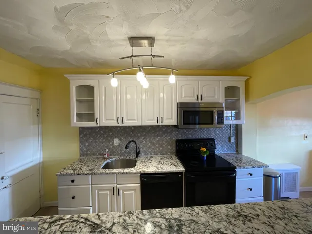 a kitchen with a sink and a stove top oven