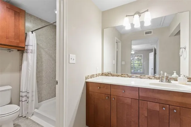 a bathroom with a sink vanity mirror and toilet