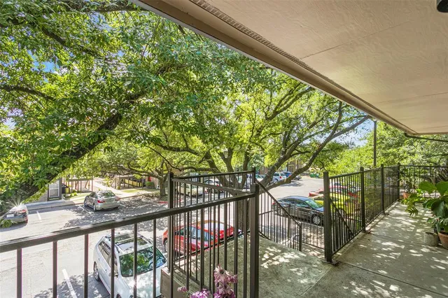 a view of trees and sign on the balcony