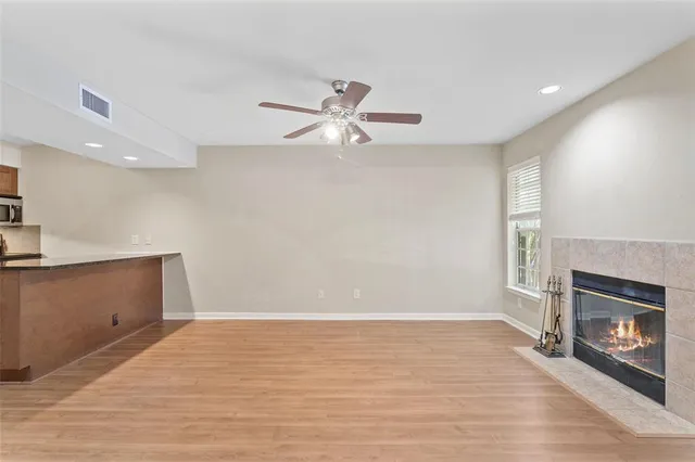 an empty room with windows and fireplace