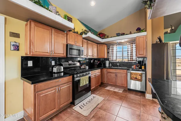 a kitchen with stainless steel appliances granite countertop a stove a sink and a refrigerator