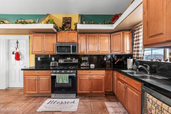 a kitchen with stainless steel appliances granite countertop a stove a sink and a microwave