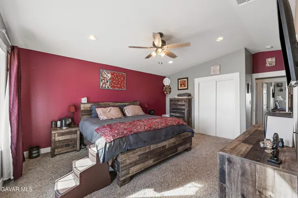 a bedroom with a bed and dresser with mirror