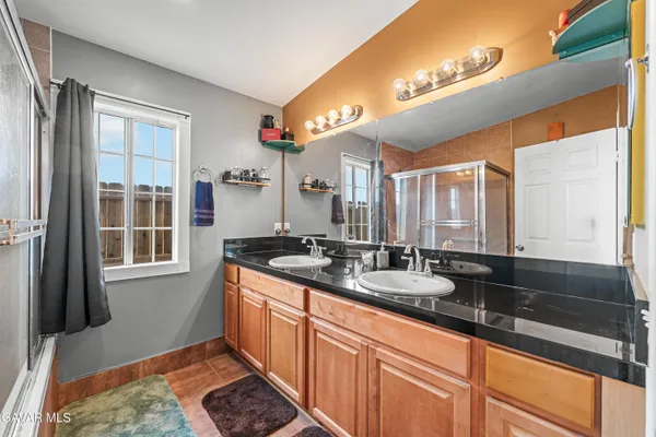a bathroom with a sink double vanity granite and a large window